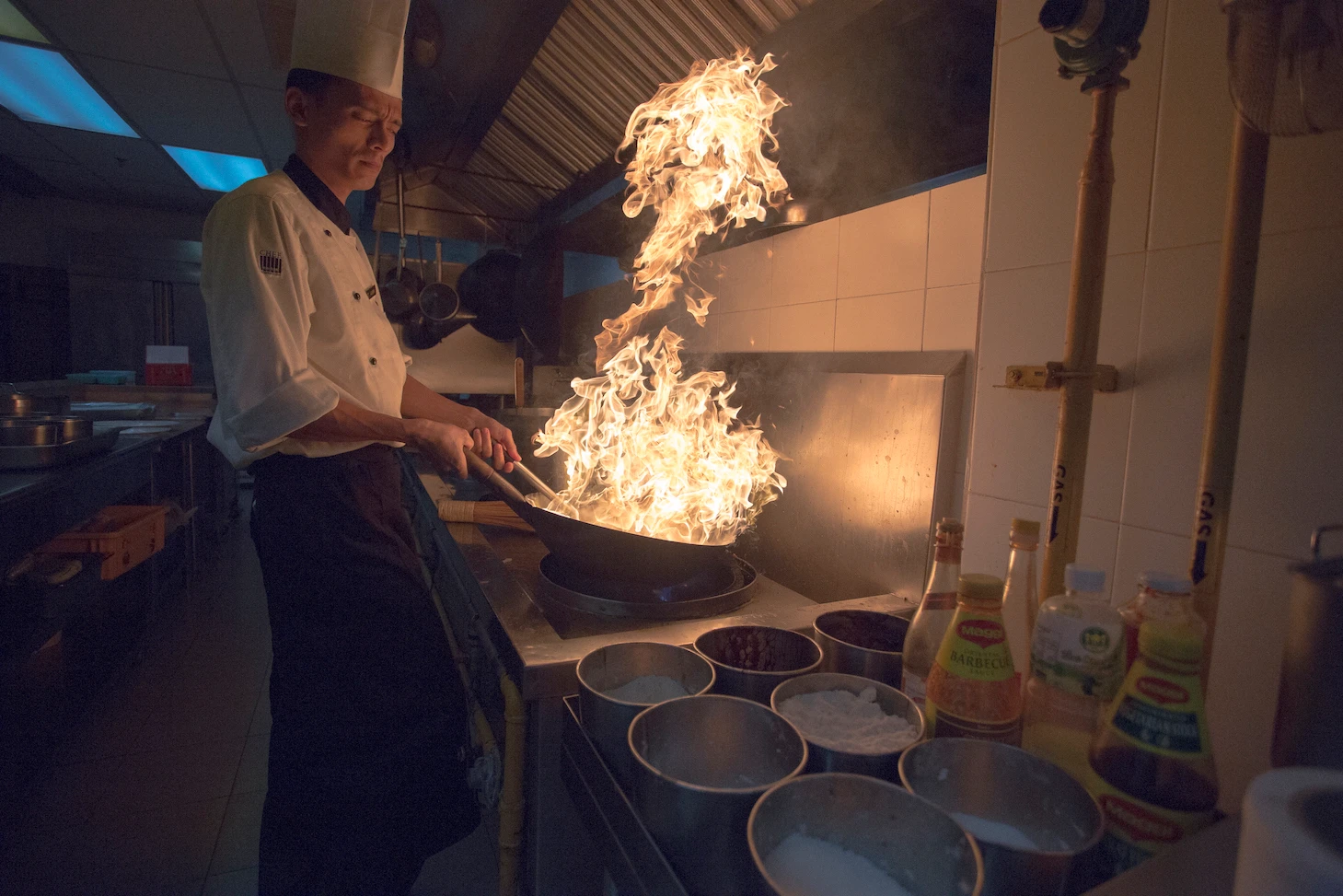 Chef cooking with flambé wok